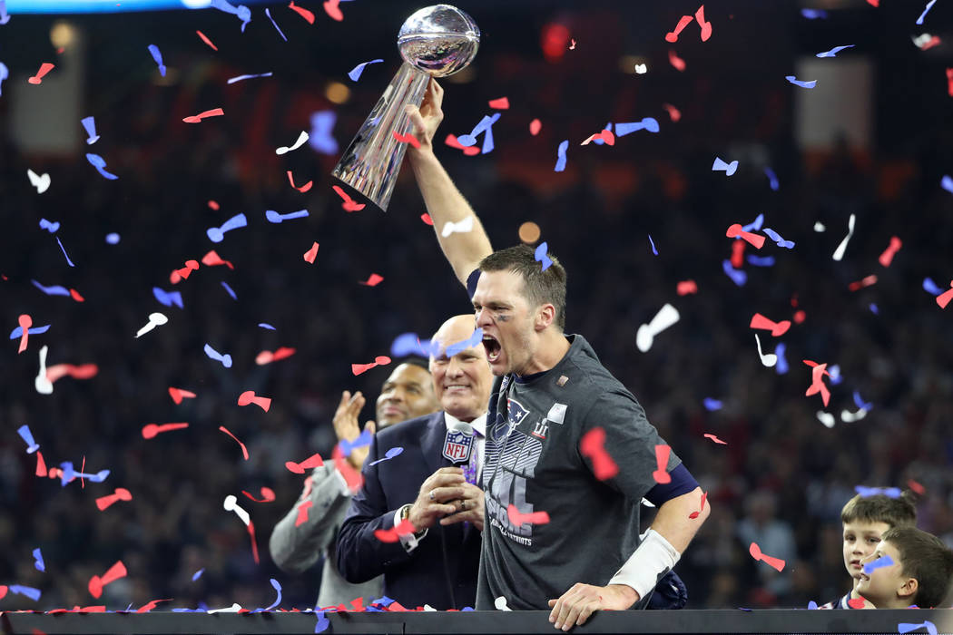 New England Patriots quarterback Tom Brady holds the Vince Lombardi trophy as interviewer Terry Bradshaw approaches after his team defeated the Atlanta Falcons to win Super Bowl LI in Houston, Tex ...