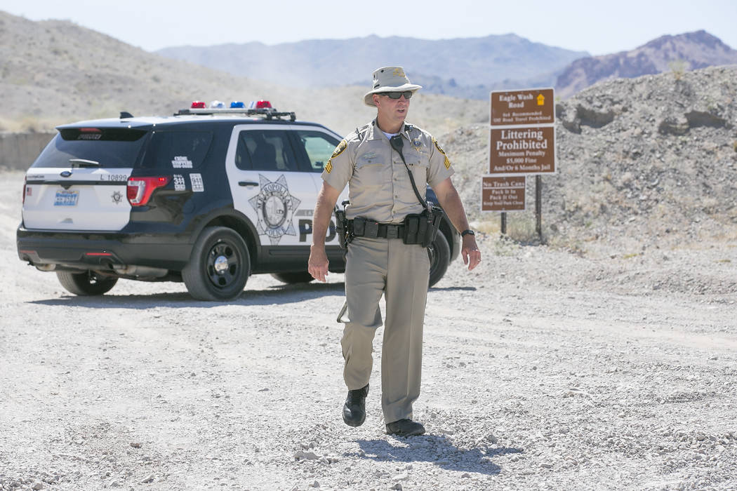 Las Vegas Metropolitan Police Srgnt. Eugene Gallagher stand guard at an entrance to Eagle Wash Road, which leads to the crime scene, at Lake Mead National Recreation Area on Tuesday, May 2, 2017.  ...