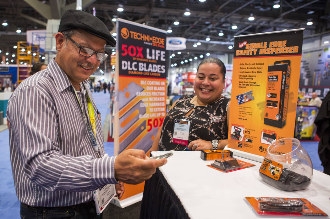 Rogelio Magana of Los Angeles, California, browses Techni Edge blades made by IDL Tools while talking with exhibitor Vanessa Hernandez at the National Hardware Show at Las Vegas Convention Center  ...