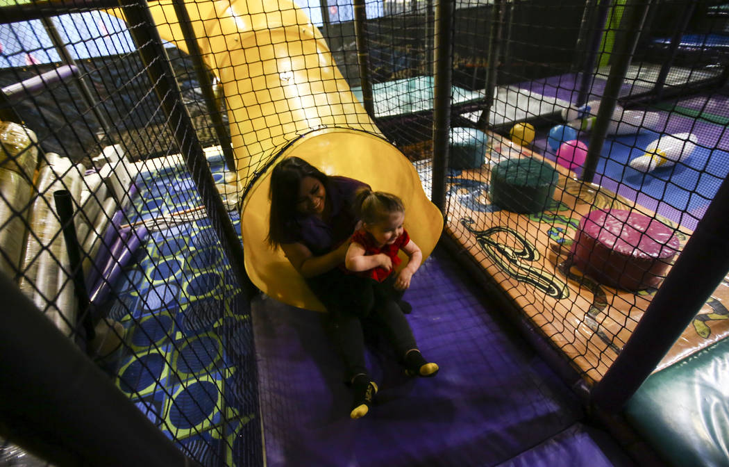 Marge Punay, a lead at Kid's Quest, goes down a slide with Emma at the Red Rock Resort hotel-casino in Las Vegas on Wednesday, May 10, 2017. Chase Stevens Las Vegas Review-Journal @csstevensphoto