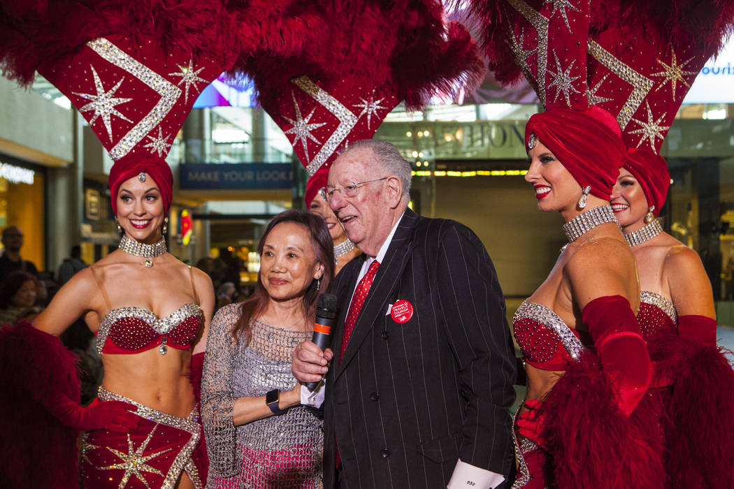 Lily Chu of Las Vegas, left, takes a photo with former Las Vegas Mayor Oscar Goodman and Viva Las Vegas showgirls during a celebration of tourism hosted by the Las Vegas Convention and Visitors Au ...