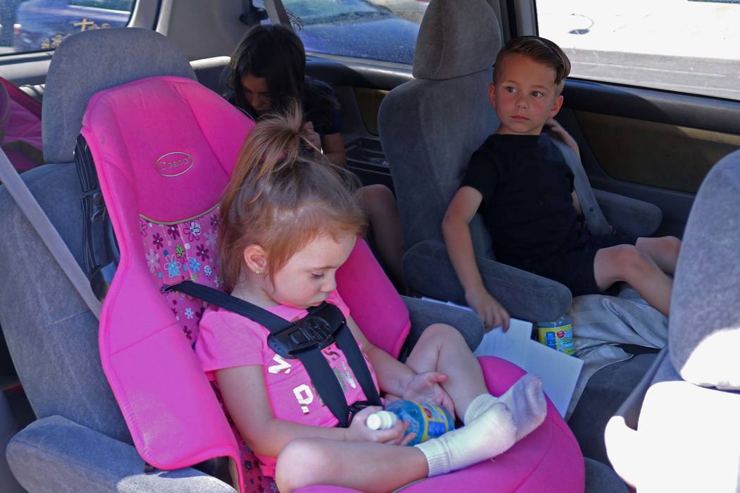 Lexie  Szelestey, 2, left, waits as her brother Christian, 5, and sister Bailey, 8, background, buckle up after getting into their mother's car at Ruth Fyfe Elementary School, Thursday, May 11, 20 ...