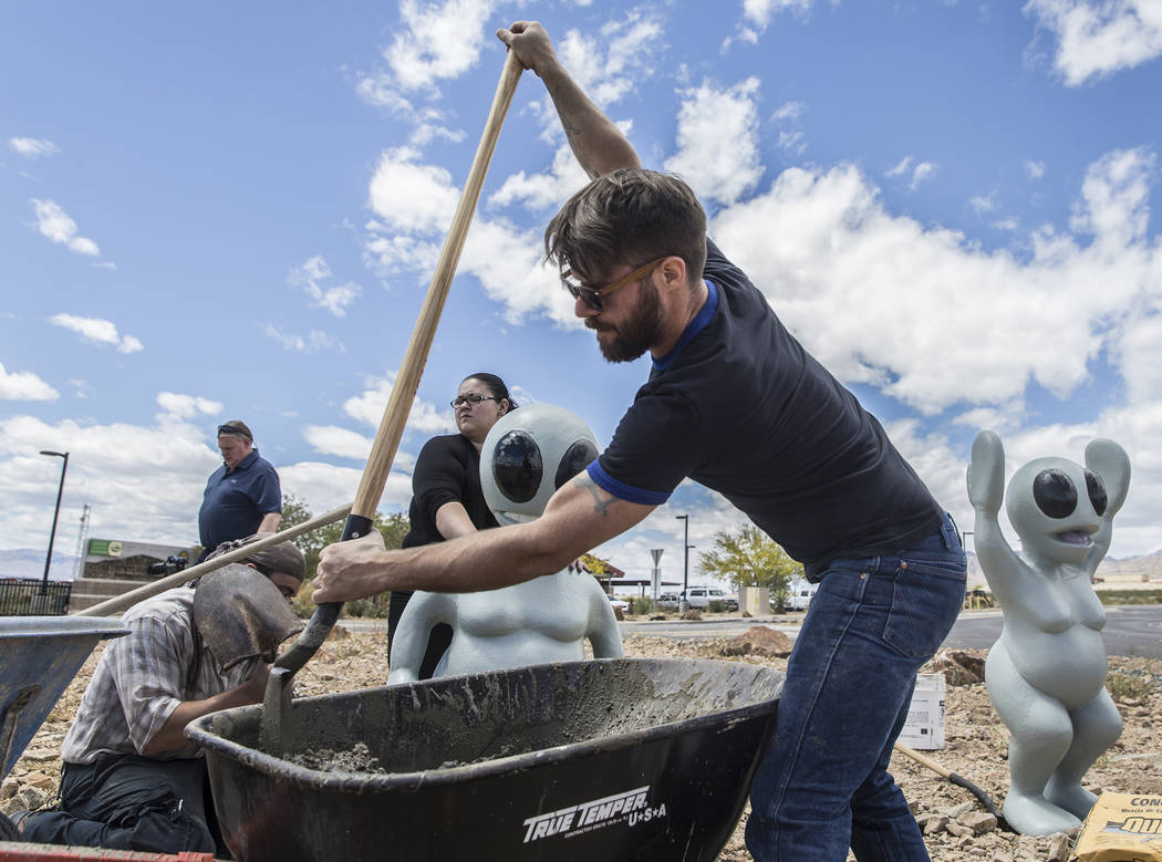 James Norman, right, shovels concrete during the installation of artist Jesse Smigel's sculpture "I Told You Not to Paint It Hot Orange" on Thursday, May 18, 2017, in Las Vegas. ...