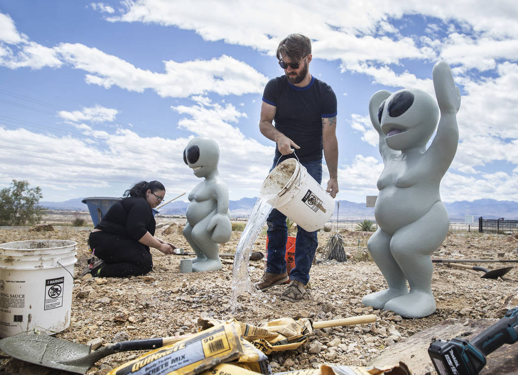 James Norman, middle, and Gia Ray work on the installation of artist Jesse Smigel's sculpture "I Told You Not to Paint It Hot Orange" on Thursday, May 18, 2017, in Las Vegas. Ben ...
