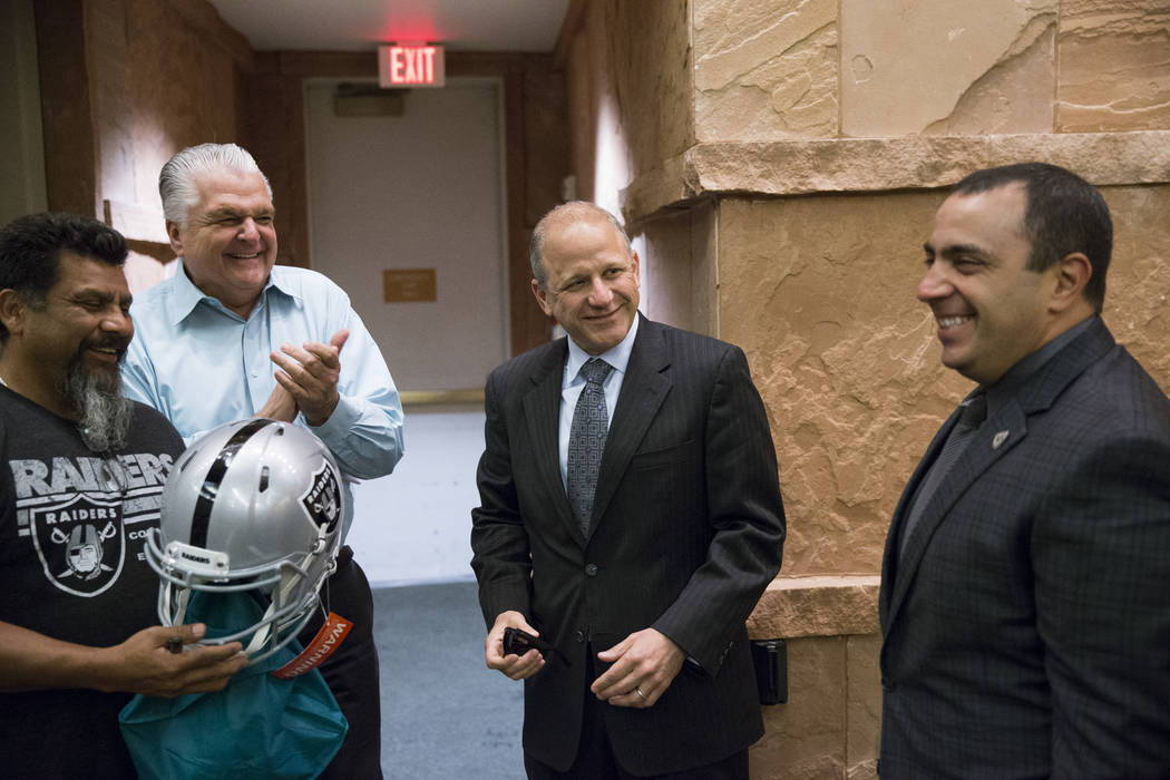 Oakland Raiders fan Carlos Garcia, from left, Clark County Commissioner Steve Sisolak, Raiders president Marc Badain, and team's executive vice president general counsel Dan Ventrelle, before a La ...