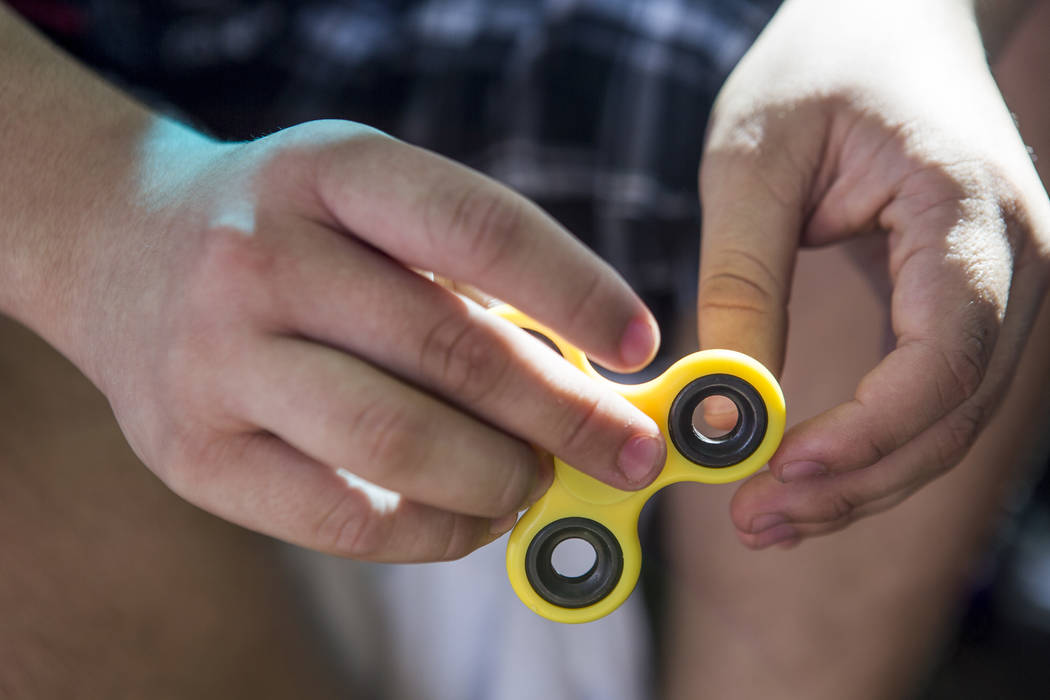 Anthony Murillo, 15, plays with his fidget spinner at Stephanie Lynn Craig Park in Henderson on Monday, May 22, 2017. Fidget spinners have been the source of scrutiny by some school teachers and o ...