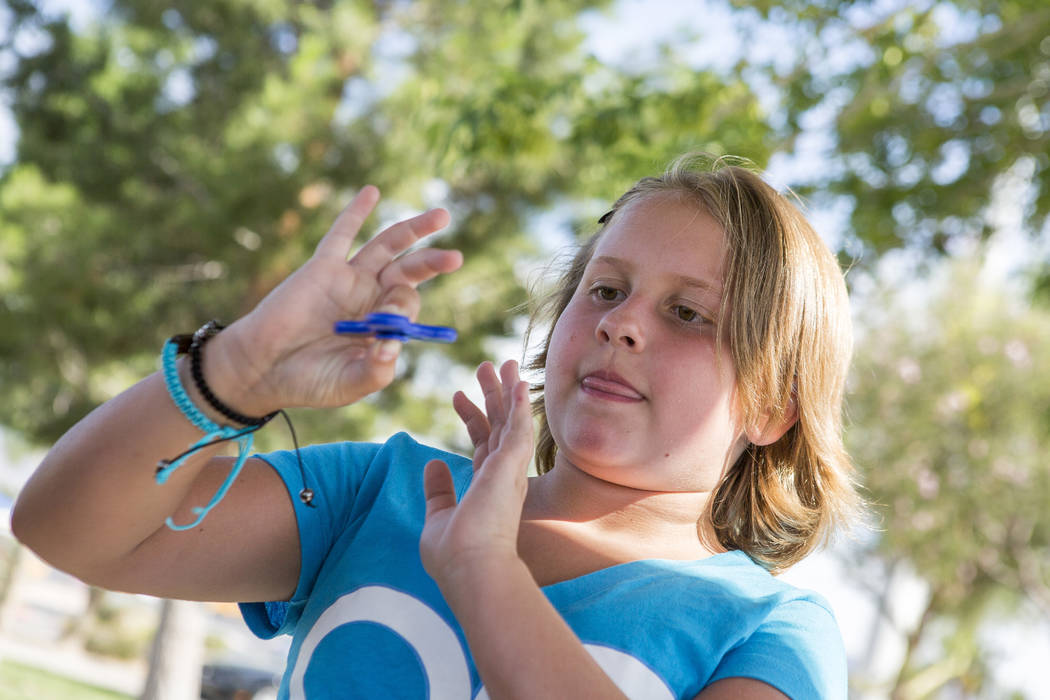Tayler Rexroad, 8, plays with her fidget spinner at Stephanie Lynn Craig Park in Henderson on Monday, May 22, 2017. Fidget spinners have been the source of scrutiny by some school teachers and off ...