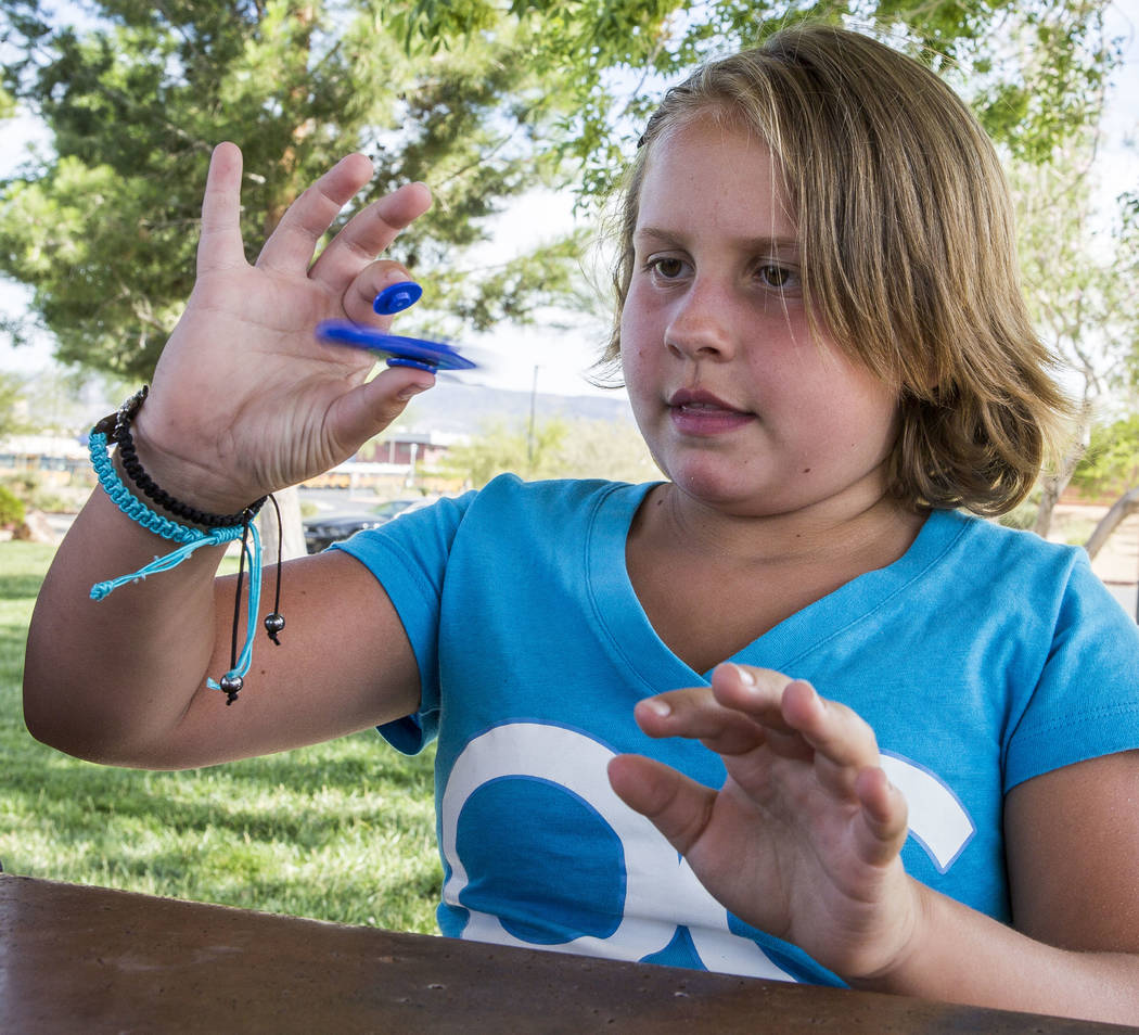Tayler Rexroad, 8, plays with her fidget spinner at Stephanie Lynn Craig Park in Henderson on Monday, May 22, 2017. Fidget spinners have been the source of scrutiny by some school teachers and off ...