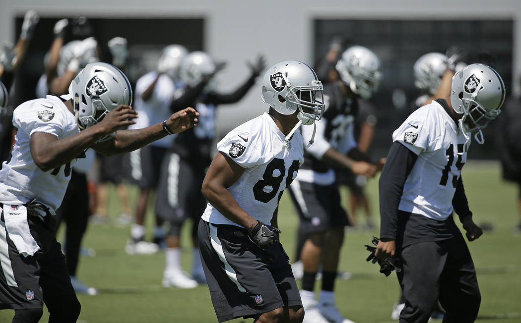 Oakland Raiders wide receiver Amari Cooper, center, stretches during an NFL football team activity Tuesday, May 23, 2017, in Alameda, Calif. (AP Photo/Eric Risberg)