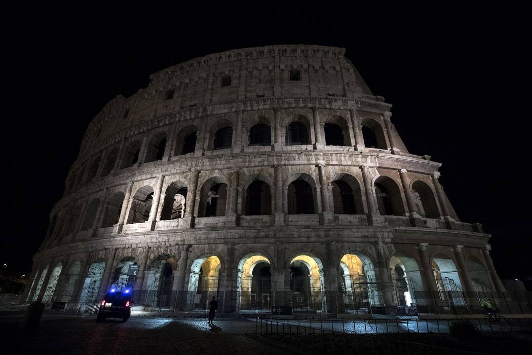 In this photo taken on Tuesday, May 23, 2017 the lights are off at the ancient Colosseum in Rome. Rome turned off the lights of the Colosseum, Trevi Fountain and city Hall Palace to honor the vict ...