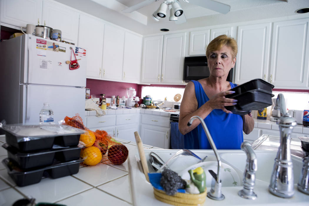 Olga Santiago puts away her Meals on Wheels delivery for her husband Rafael Santiago-Figueroa who suffers from multiple sclerosis at their home in Las Vegas, Thursday, May 25, 2017. Elizabeth Brum ...