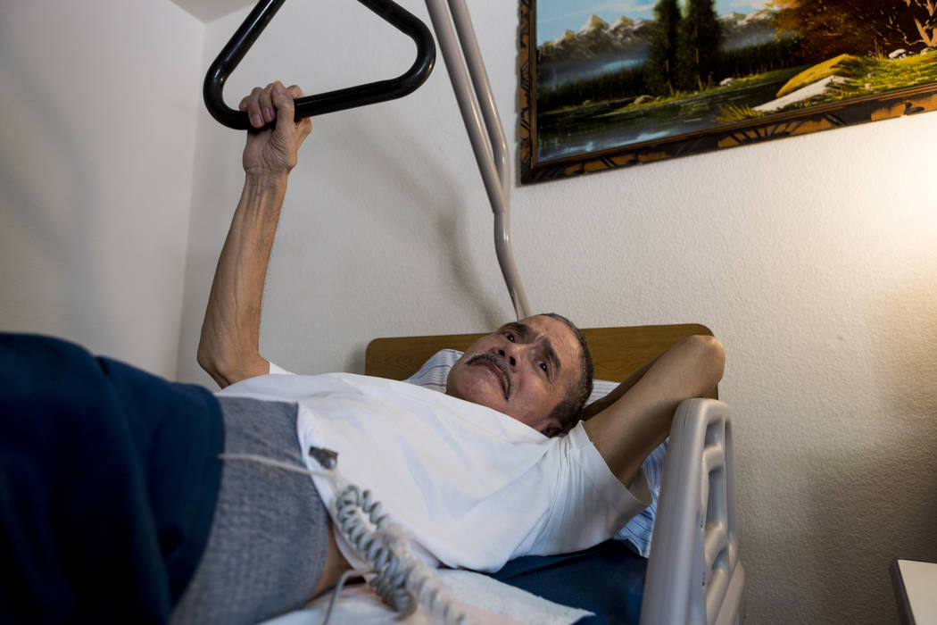 Rafael Santiago-Figueroa who suffers from multiple sclerosis watches television while his wife puts away his Meals on Wheels delivery in their home in Las Vegas, Thursday, May 25, 2017. Elizabeth ...