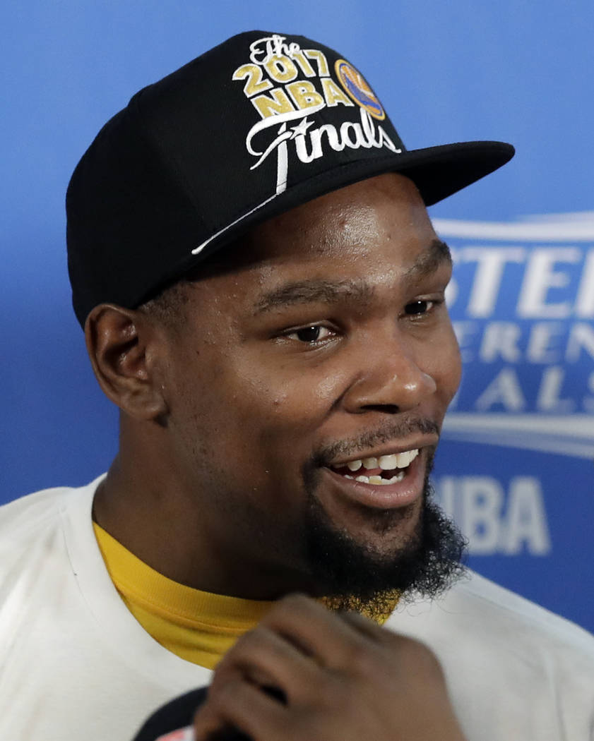 Golden State Warriors' Kevin Durant wears a Finals cap during the trophy presentation after their 129-115 win over the San Antonio Spurs in Game 4 of the NBA basketball Western Conference finals,  ...
