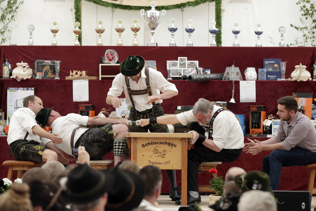 A man dressed in traditional clothes tries to pull his opponent over the table at the 40th Alpine Country Championships in Fingerhakeln in Woernsmuehl, Germany, Thursday, May 25, 2017. Competitors ...