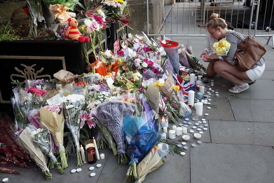 People lay flowers after a vigil in Albert Square, Manchester, England, Tuesday May 23, 2017, the day after the suicide attack at an Ariana Grande concert that left 22 people dead. (Kirsty Wiggles ...