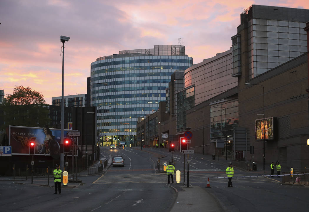 Police stand guard at dawn, after a blast at the Manchester Arena Tuesday, May 23, 2017. An explosion struck an Ariana Grande concert attended by thousands of young fans in northern England Monday ...