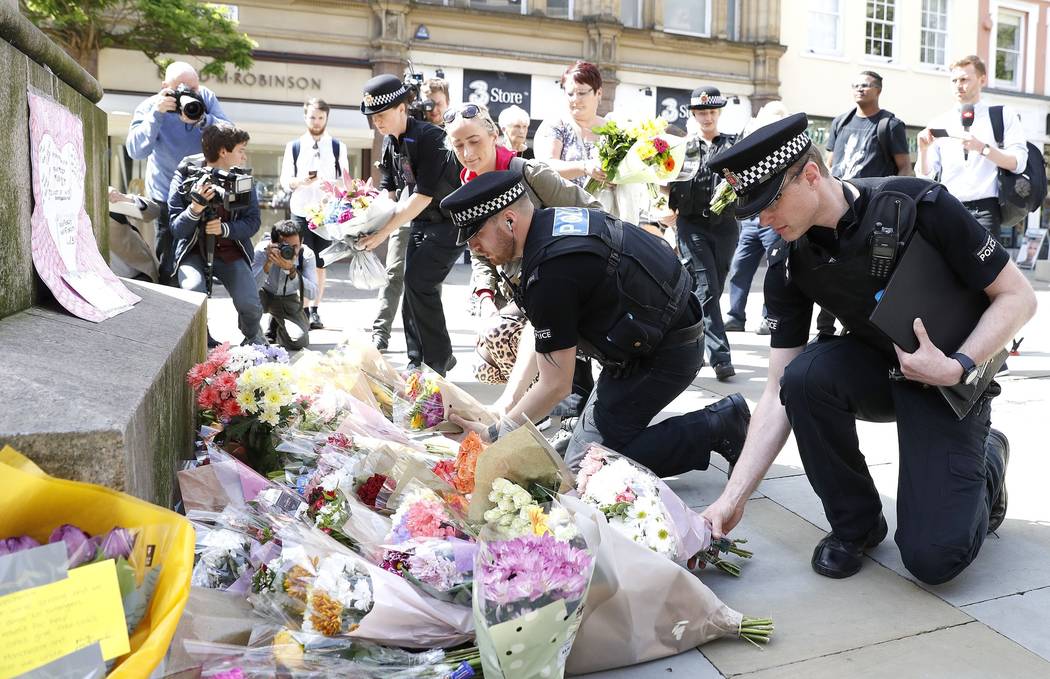 Police offices add to the flowers for the victims of Monday night pop concert explosion, in St Ann's Square, Manchester,  Tuesday May 23, 2017. A 23-year-old man was arrested in connection with Mo ...