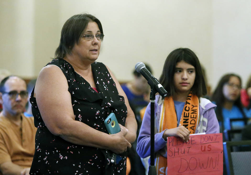 Nevada Connections Academy student, Caitlin Droegemueller, 7, holds a sign as her mother Dianna Thompson, delivers her comments during the State Public Charter School Authority meeting Thursday, M ...