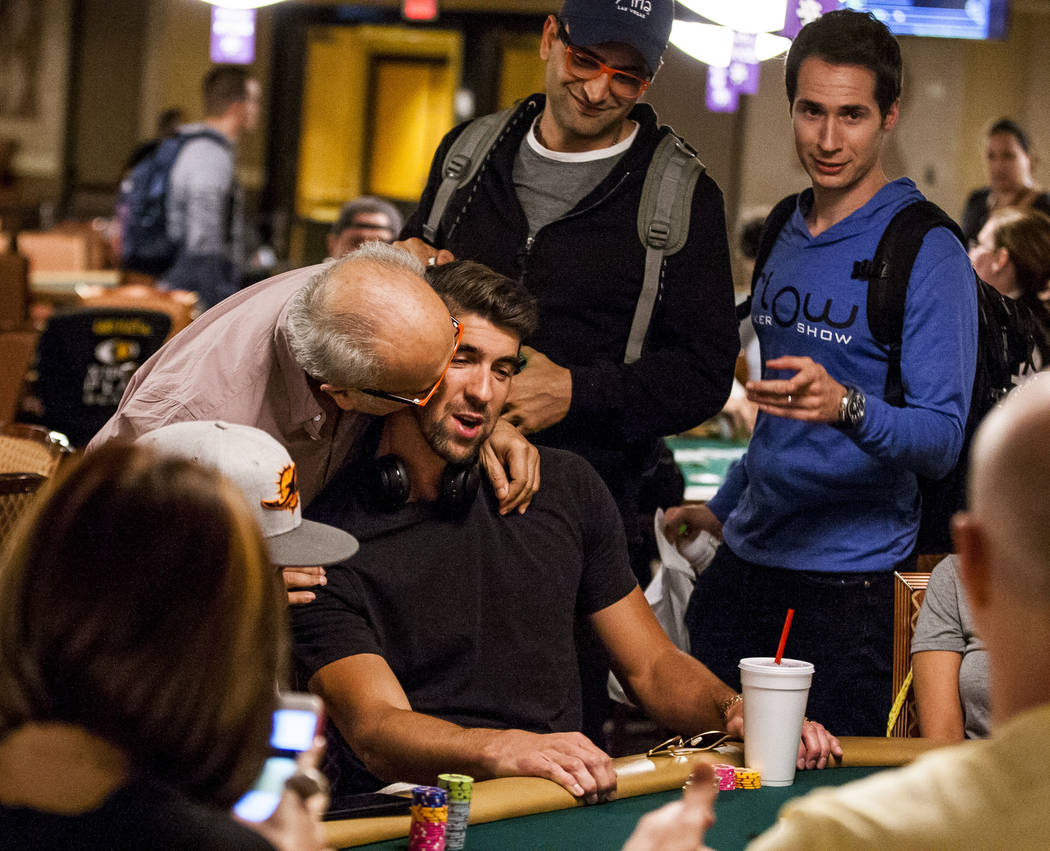 Bejan Esfandiari, father of poker star Antonio Esfandiari, gives Olympic swimmer Michael Phelps plays poker during a tag team event in the opening of the World Series of Poker at the Rio Conventio ...