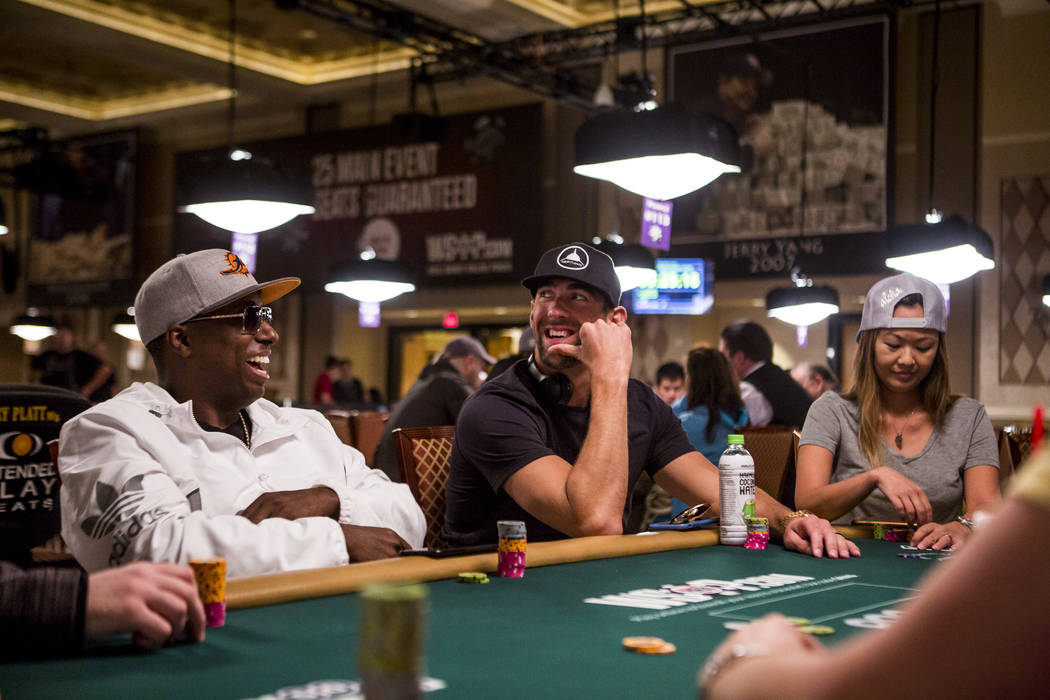Olympic swimmer Michael Phelps shares a moment with poker star Maurice Hawkins during a tag team event in the opening of the World Series of Poker at the Rio Convention Center on Wednesday, May 31 ...