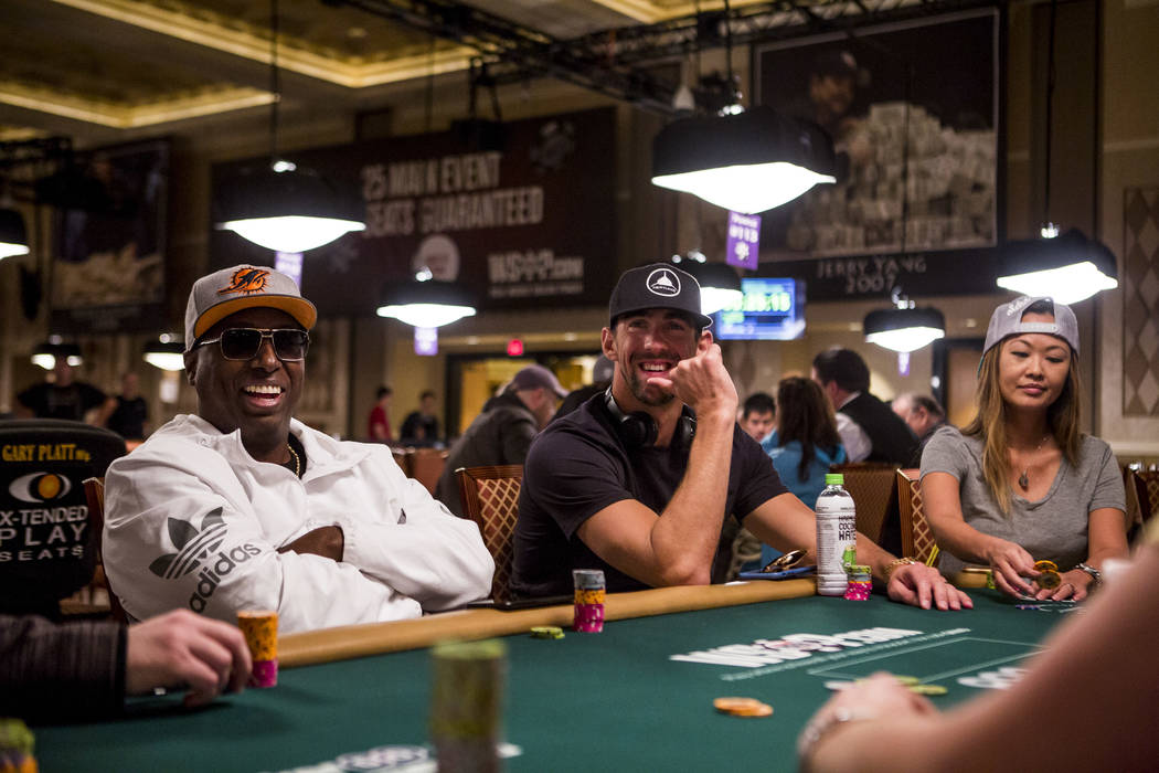 Olympic swimmer Michael Phelps shares a moment with poker star Maurice Hawkins during a tag team event in the opening of the World Series of Poker at the Rio Convention Center on Wednesday, May 31 ...