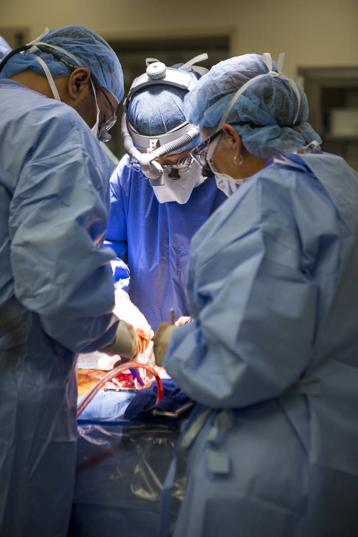 Dr. Quynh Feikes, center, performs a surgery to fix an abdominal aneurysm with help from assistant Tracy Blankenship, right, and Dr. Deepak Malhotra at University Medical Center on Tuesday, May 23 ...