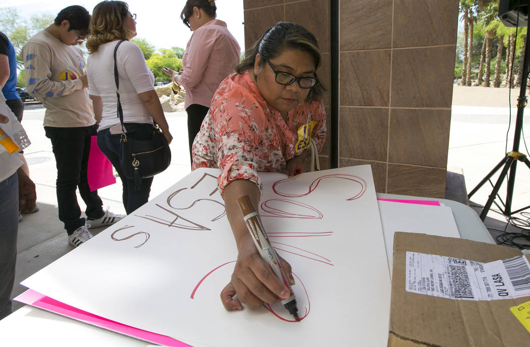 A woman makes a signs before the start of a rally supporting a measure for the Nevada Education Savings Account outside of the Grant Sawyer Building in Las Vegas on Saturday, June 3, 2017. Richard ...