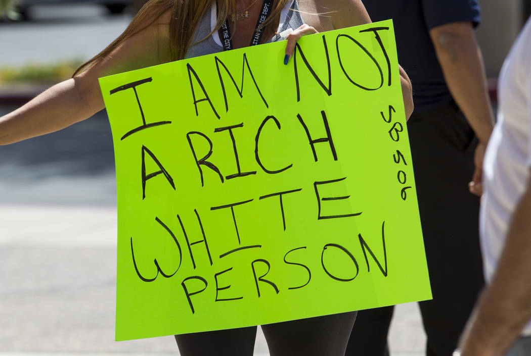 People hold signs as they participate in a rally supporting a measure for the Nevada Education Savings Account outside of the Grant Sawyer Building in Las Vegas on Saturday, June 3, 2017. Richard  ...