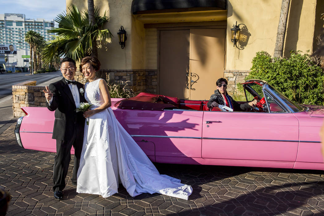 Garry and Julie Kim take photos next to the pink Cadillac after renewing their wedding vows in an Elvis-themed ceremony at the Viva Las Vegas Wedding Chapel on Saturday, June 3, 2017.  Patrick Con ...