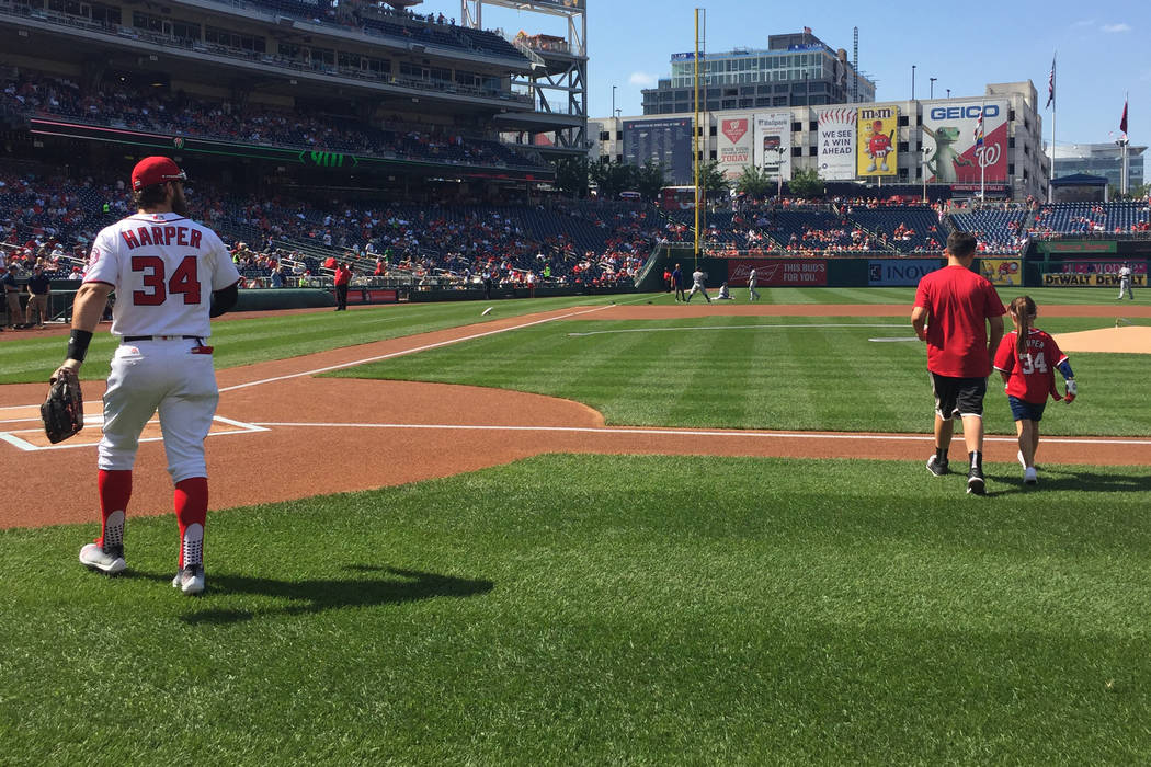 Las Vegas' Bryce Harper and fellow Las Vegan Hailey Dawson (and her brother, Zach) head onto the field where she threw out the ceremonial first pitch before the June 11 game between the Washington ...