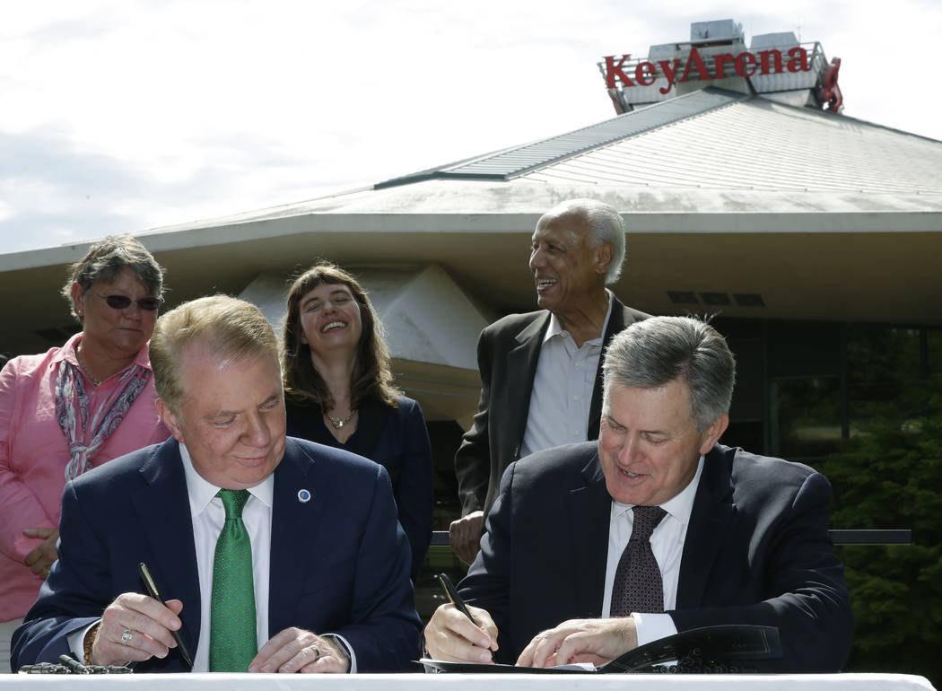 Seattle Mayor Ed Murray, left, and Tim Leiweke, right, CEO of the Oak View Group take part in a signing ceremony during during a news conference, Wednesday, June 7, 2017, in Seattle. Murray said t ...
