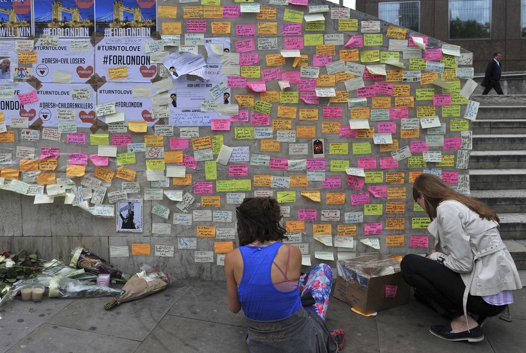 People leave messages of support on the base of the obelisk on London Bridge Thursday June 8, 2017, after an unidentified man left a box of tape, sticky notes and marker pens with an invite to wri ...