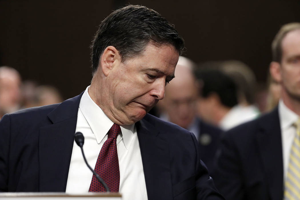 Former FBI Director James Comey reacts after bumping something under the table, during a Senate Intelligence Committee hearing on Capitol Hill, Thursday, June 8, 2017, in Washington. (AP Photo/Ale ...