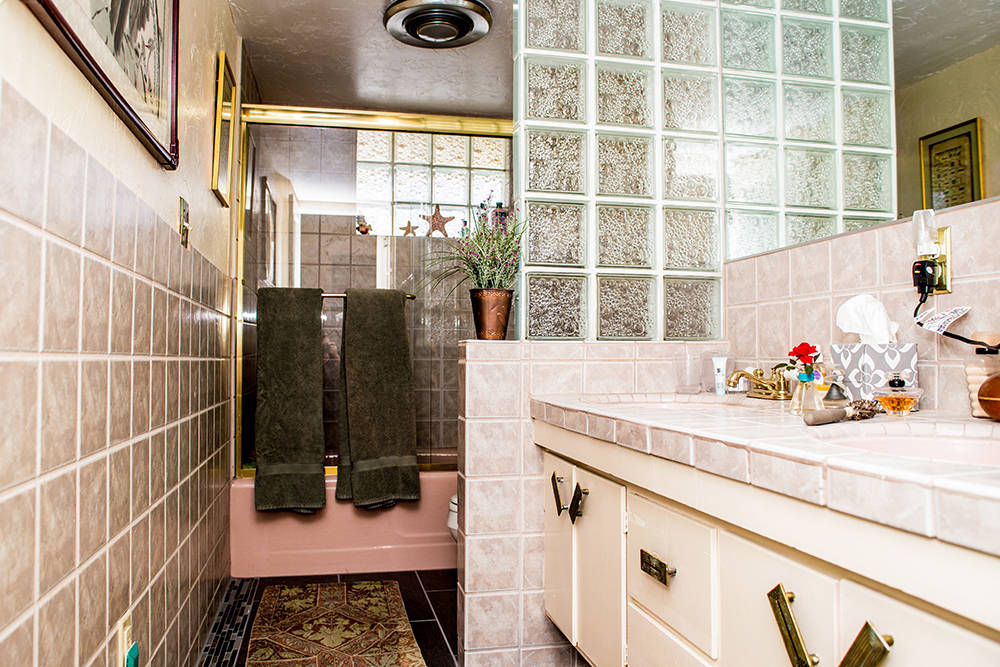 Other rooms were left untouched to preserve the original charm. One bath has a pink tub and matching pink sinks with a glass block wall accent, which in 1964 was a new trend. (Tonya Harvey Real Es ...