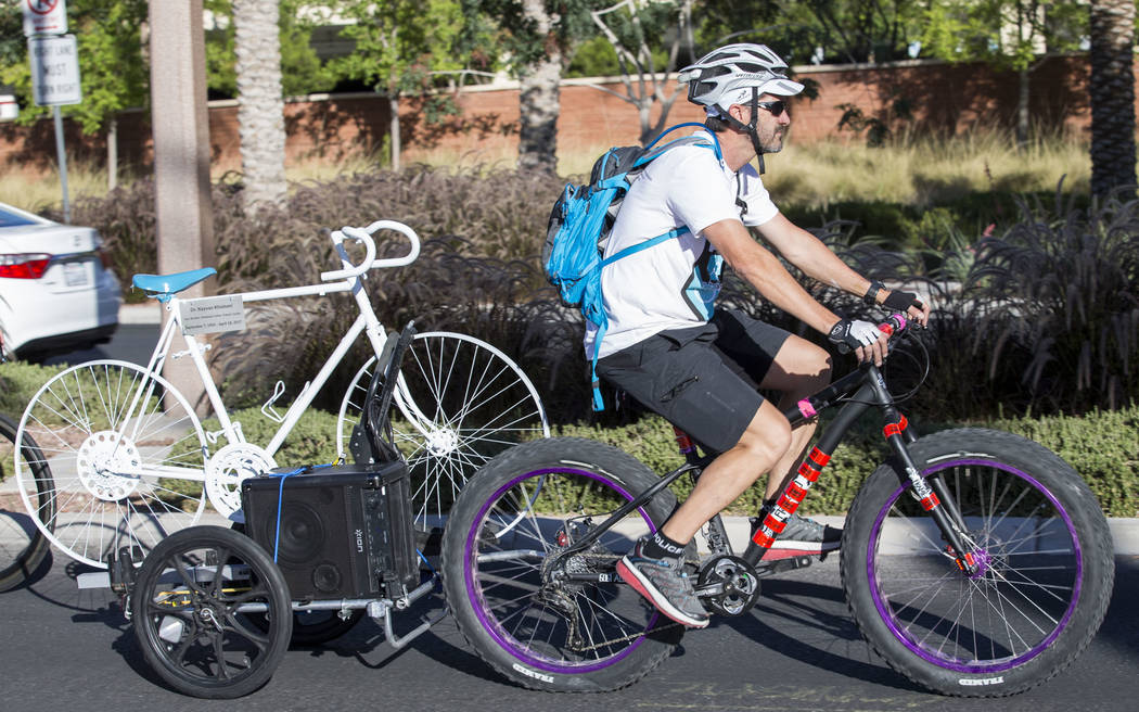 Pat Treichel, founder Ghost Bikes Las Vegas, tows the ghost bike of Dr. Kayvan Khiabani during a group ride along South Pavillion Center Drive near West Charleston Boulevard on Saturday, June 17,  ...