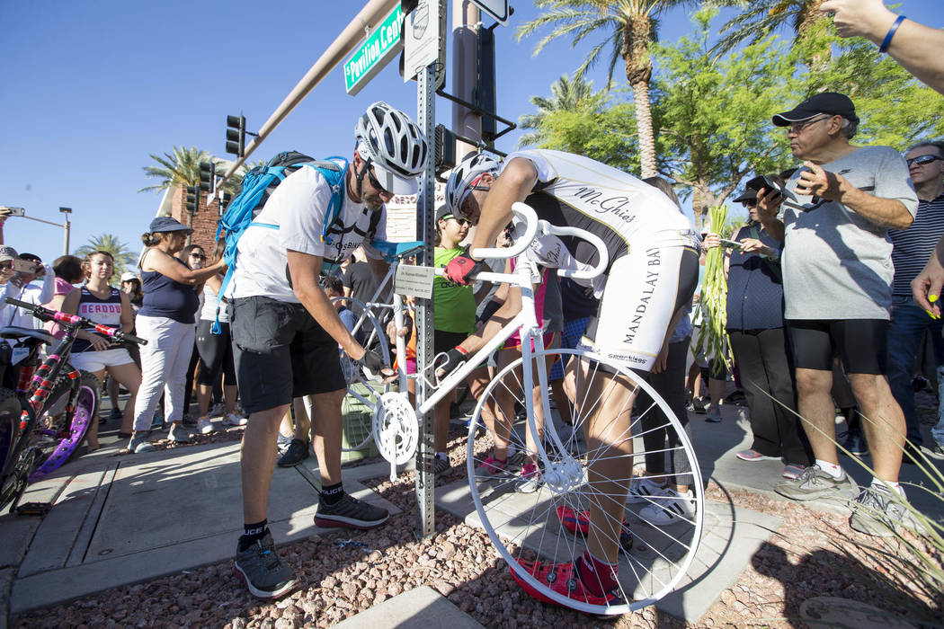 Ghost Bikes Las Vegas founder Pat Treichel, left, and fellow cyclist Michael Verni set up the ghost bike of Dr. Kayvan Khiabani during a memorial service at the corner South Pavillion Center Drive ...