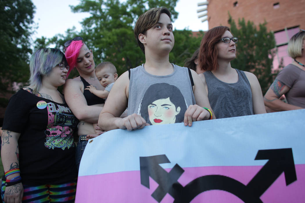 Danielle Anderson, from left, Rebel Rae, holding their son Dani Brown, Lyndon Rohde, and Zoey Henderson stand with a trans pride poster on Sunday, June 11, 2017, at the Equality Rally for Unity an ...