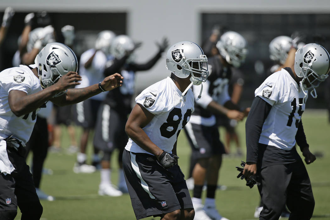 Oakland Raiders wide receiver Amari Cooper, center, stretches during an NFL football team activity Tuesday, May 23, 2017, in Alameda, Calif. (AP Photo/Eric Risberg)