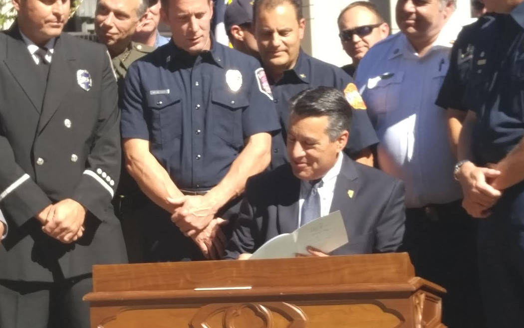 Gov. Brian Sandoval signs bills on Wednesday in Carson City that allow a firefighters memorial at the state Capitol Complex and put enhanced penalties in place for crimes against first responders, ...