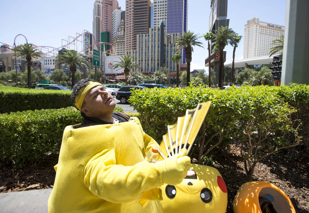 Street performer Ruben Osorio waves a fan to cool off as he takes a break from posing for photos with tourists as Pikachu along The Strip on Monday, June 19, 2017. Richard Brian Las Vegas Review-J ...