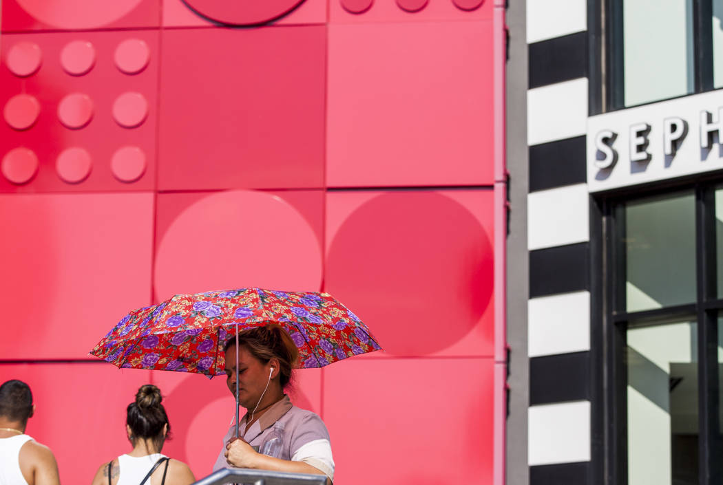 A pedestrian walks by the Miarcle Mile shops using a sun umbrella on the Las Vegas Strip as the temperature reached 116 on Tuesday, June 20, 2017. Patrick Connolly Las Vegas Review-Journal @PConnPie
