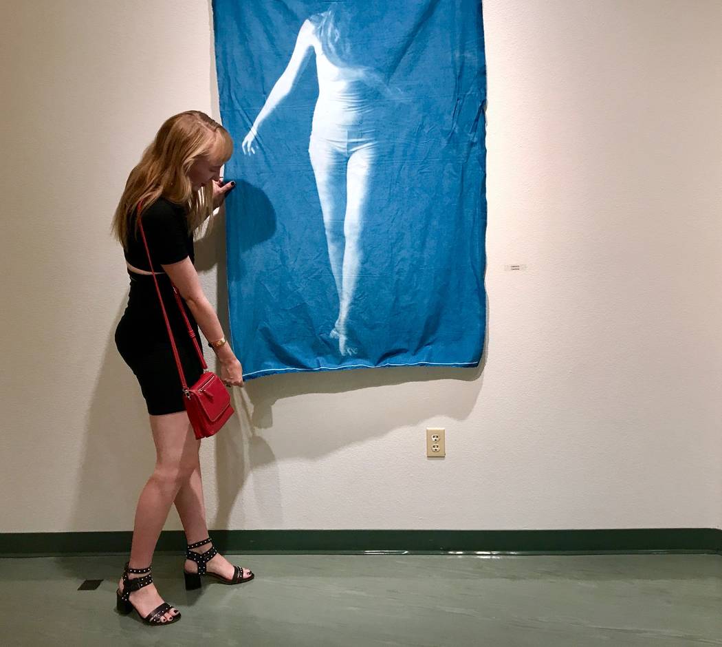 Melissa Gaudet examines one of her life-sized cyanotype blueprints on display in the art gallery at the West Charleston Public Library. (Madelyn Reese/View) @MadelynGReese