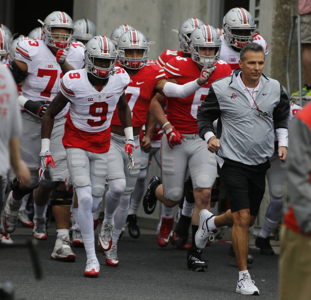 Ohio State head coach Urban Meyer leads his team on to the field for their NCAA college spring football game Saturday, April 15, 2017, in Columbus, Ohio. (AP Photo/Jay LaPrete)