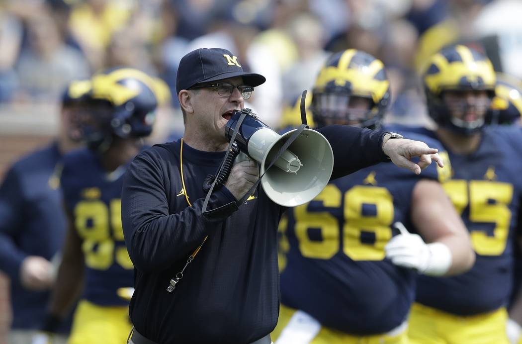 FILE - In this April 15, 2017, file photo, Michigan head coach Jim Harbaugh talks to his players during the NCAA college football team's spring game, in Ann Arbor, Mich. The increasing visibility  ...
