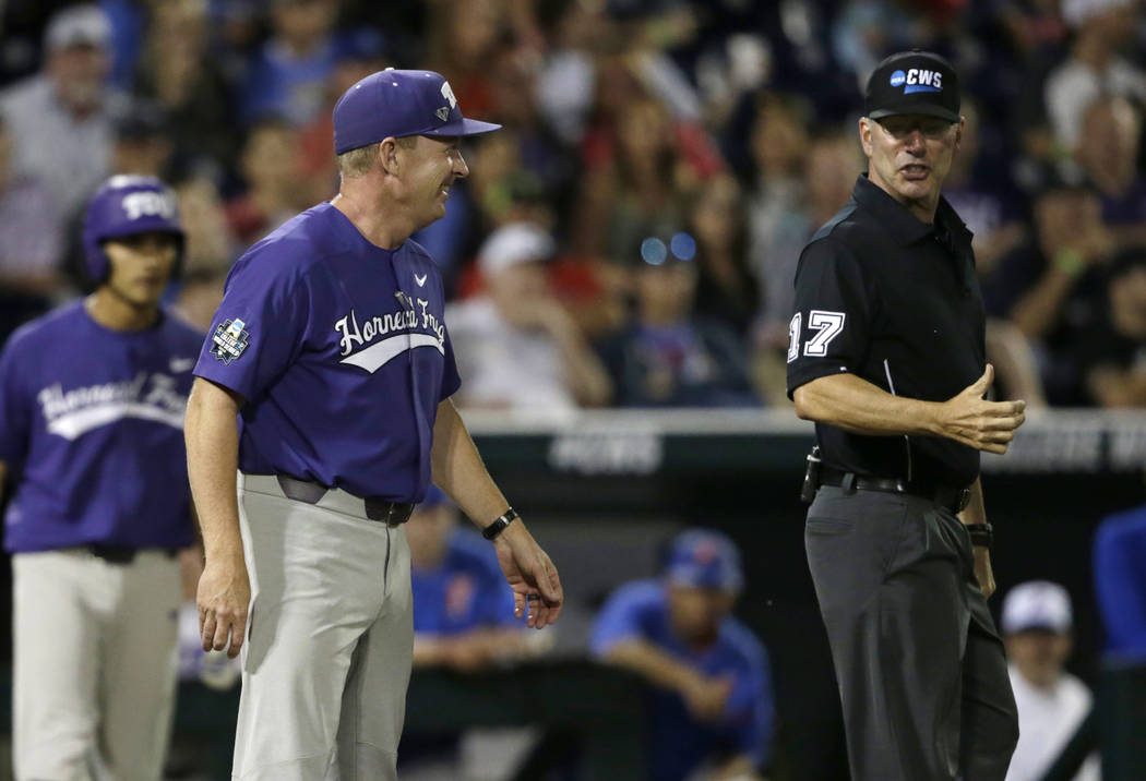 TCU coach Jim Schlossnagle, center, goes out to talk to home plate umpire Steve Mattingly, right, about a ball hit by Elliott Barzilli for a foul ball in the seventh inning of an NCAA College Worl ...