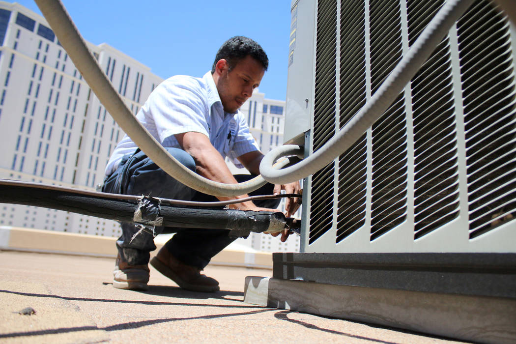 In this July 1, 2014  file photo, air conditioner repairman, Peter Almanza of Cal Air works on an air conditioning unit on the roof of Planet Hollywood Miracle Mile Shops in Las Vegas. (Rachel Cro ...