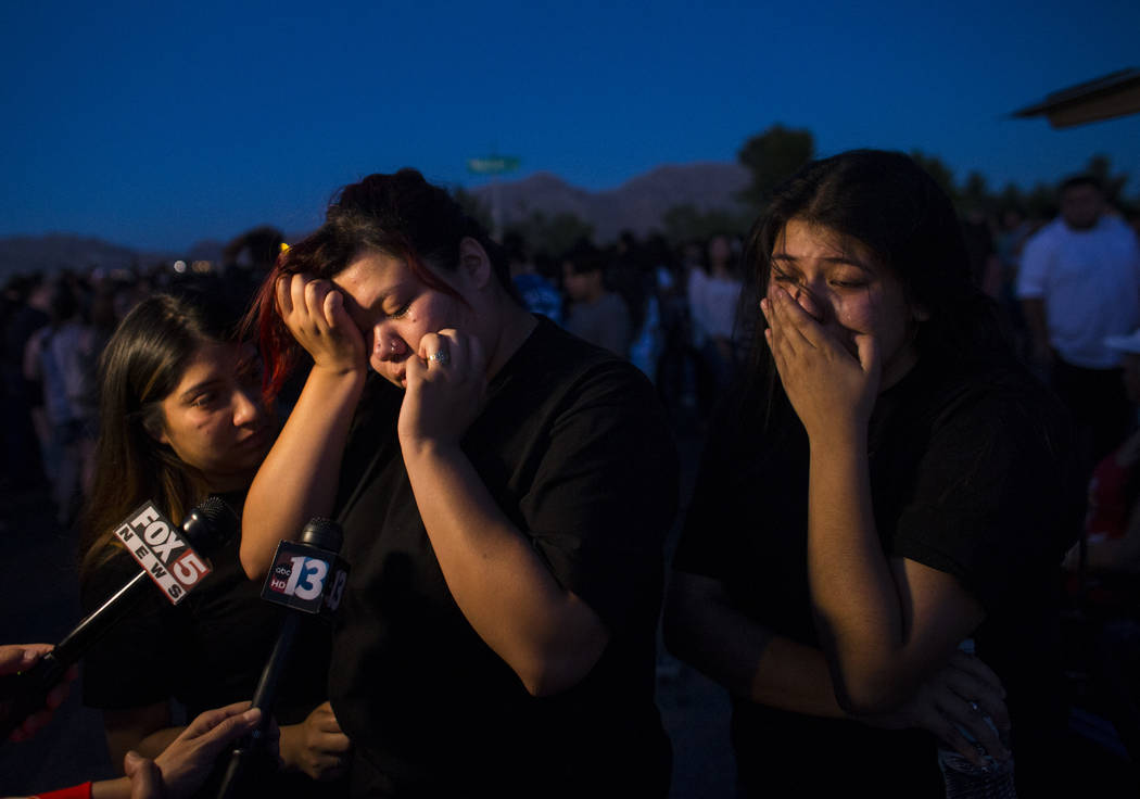 Angelica Reyes, left, reacts during a candlelight vigil for teenagers Oscar Ayala and Moises Rivera, who both died in a crash caused by a drunk driver this past Saturday, at Marion Drive and Judah ...