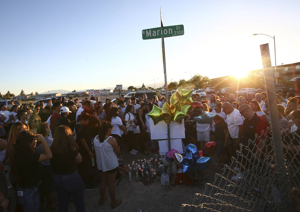 People gather during a candlelight vigil for teenagers Oscar Ayala and Moises Rivera, who both died in a crash caused by a drunk driver this past Saturday, at Marion Drive and Judah Avenue in Las  ...