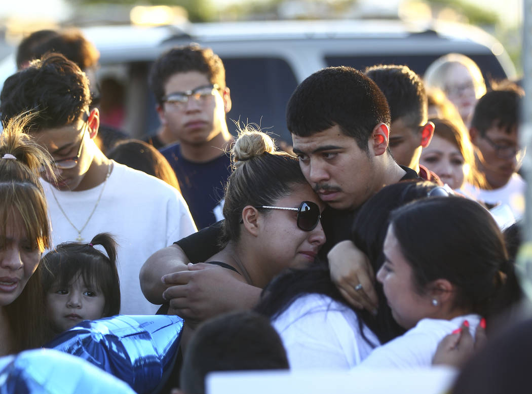 People console one another during a candlelight vigil for teenagers Oscar Ayala and Moises Rivera, who both died in a crash caused by a drunk driver this past Saturday, at Marion Drive and Judah A ...