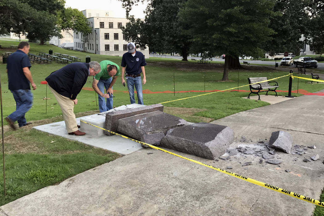 Personnel from the Secretary of State's office inspect the damage to the new Ten Commandments monument outside the state Capitol in Little Rock, Ark., Wednesday morning, June 28, 2017, after someo ...